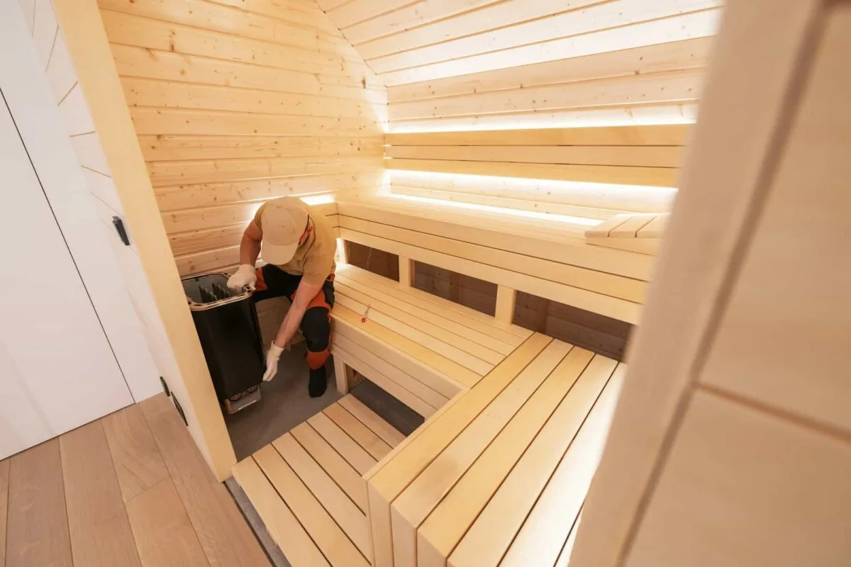 Installateur professionnel mettant en place un sauna traditionnel chez un particulier