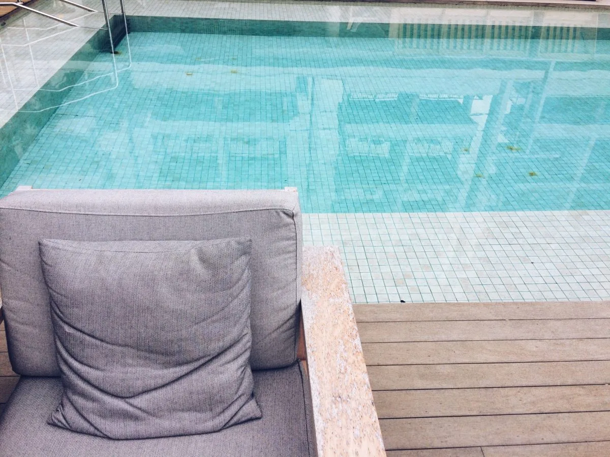 Abri de piscine en bois élégant à côté d'une piscine scintillante